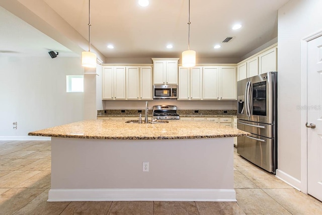 kitchen with stainless steel appliances, a sink, light stone countertops, a center island with sink, and recessed lighting