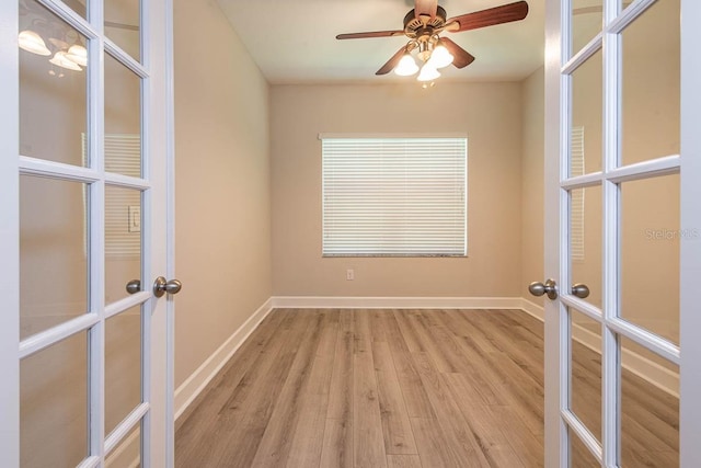 unfurnished room featuring french doors, light wood-type flooring, and baseboards