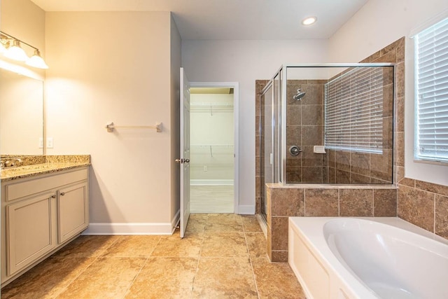 full bathroom with a stall shower, vanity, a bath, a walk in closet, and recessed lighting