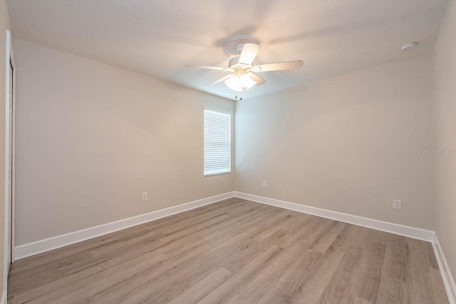 spare room with light wood-style floors, baseboards, a ceiling fan, and a smoke detector