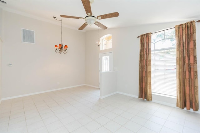 empty room with ceiling fan with notable chandelier, baseboards, a healthy amount of sunlight, and visible vents