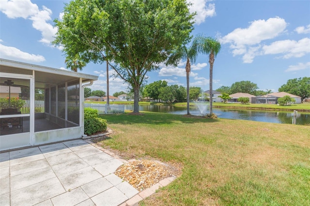 view of yard with a sunroom, a water view, and fence