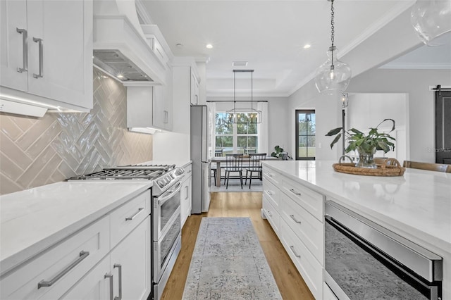 14902 Sweat Loop Rd, Wimauma, FL 33598 - kitchen with appliances with stainless steel finishes, white cabinets, tasteful backsplash, hanging light fixtures, and crown molding