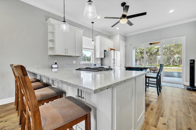 14902 Sweat Loop Rd, Wimauma, FL 33598 - kitchen with white refrigerator with ice dispenser, a peninsula, white cabinets, light wood finished floors, and a kitchen breakfast bar