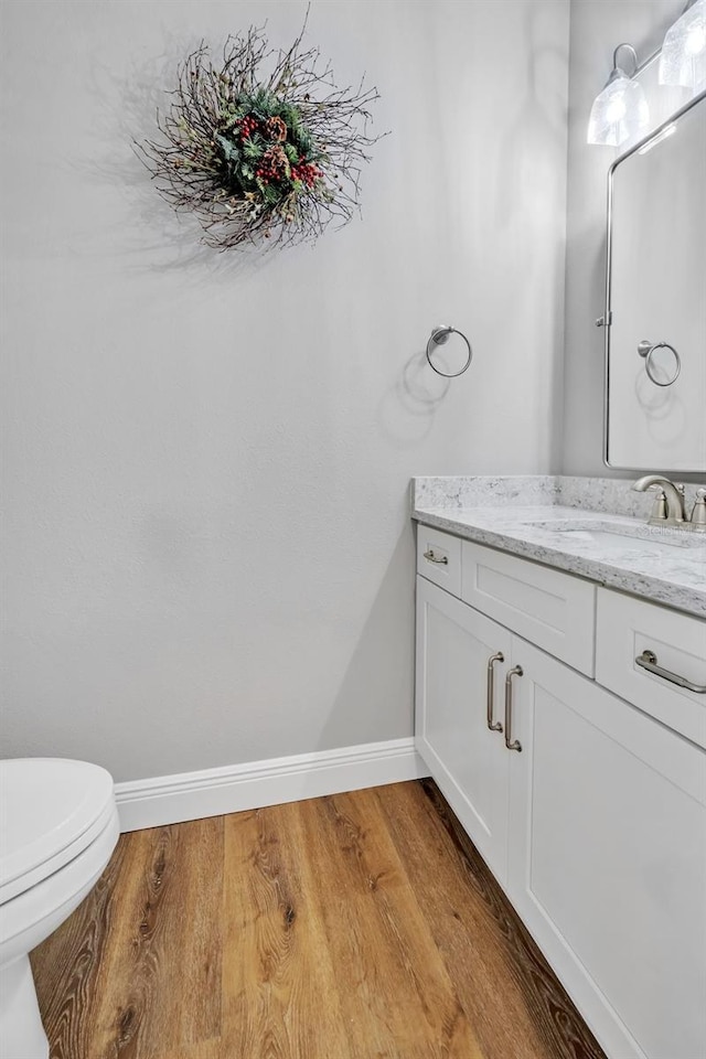 14902 Sweat Loop Rd, Wimauma, FL 33598 - bathroom featuring baseboards, wood finished floors, vanity, and toilet