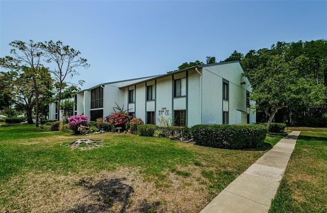 1290 Pine Ridge Cir E Unit G1, Tarpon Springs, FL 34688 - view of side of home with stucco siding and a yard
