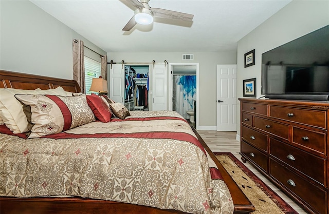 1290 Pine Ridge Cir E Unit G1, Tarpon Springs, FL 34688 - bedroom with light wood-style flooring, a walk in closet, a closet, ceiling fan, and baseboards