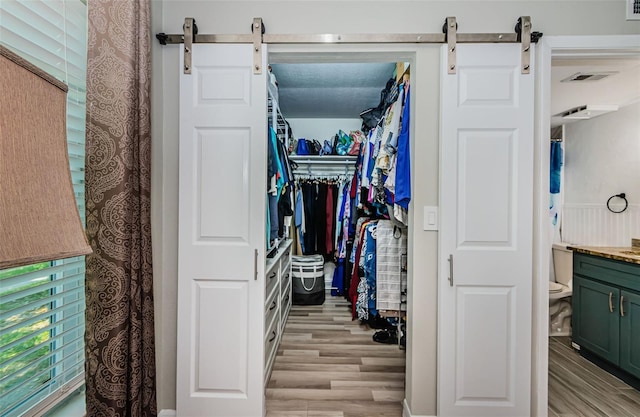 1290 Pine Ridge Cir E Unit G1, Tarpon Springs, FL 34688 - spacious closet featuring a barn door and light wood-type flooring
