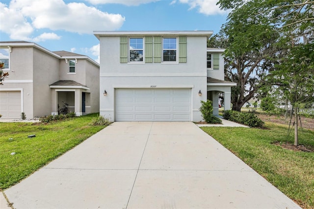 traditional-style house featuring concrete driveway, a garage, stucco siding, and a front yard