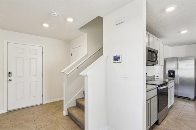 kitchen with light tile patterned flooring, baseboards, recessed lighting, and appliances with stainless steel finishes