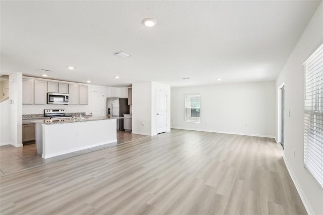 unfurnished living room featuring light wood-style floors, baseboards, and recessed lighting