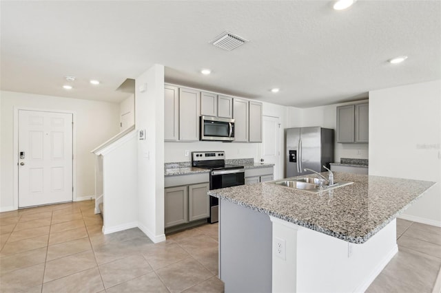 kitchen featuring light tile patterned floors, visible vents, a sink, stainless steel appliances, and gray cabinets