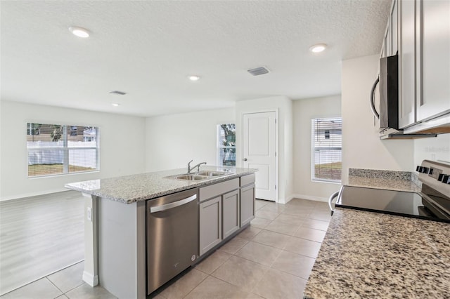 kitchen with gray cabinets, plenty of natural light, stainless steel appliances, and a sink