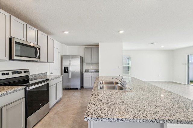 kitchen featuring a wealth of natural light, appliances with stainless steel finishes, gray cabinets, and a sink
