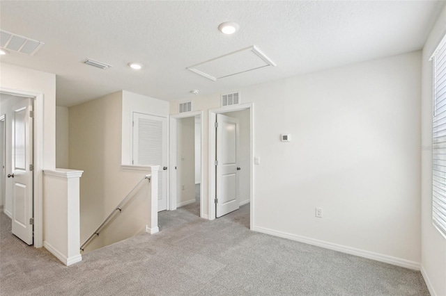 spare room with light colored carpet and visible vents