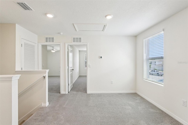 unfurnished room featuring baseboards, light carpet, and visible vents