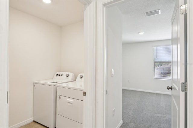 laundry area with light colored carpet, washing machine and clothes dryer, baseboards, and laundry area