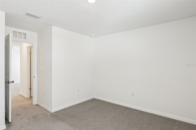 unfurnished room with baseboards, light carpet, and visible vents