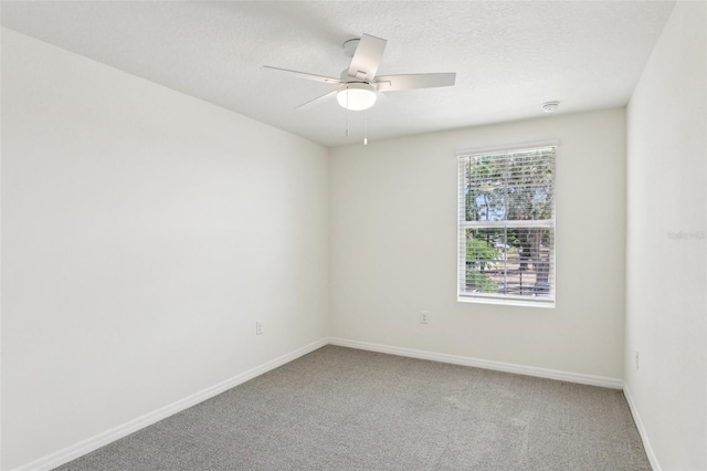 empty room with baseboards, a textured ceiling, a ceiling fan, and light colored carpet