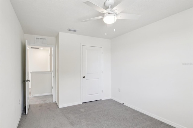 unfurnished bedroom with baseboards, a ceiling fan, visible vents, and carpet floors