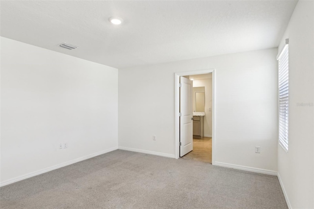 interior space with light carpet, baseboards, and visible vents