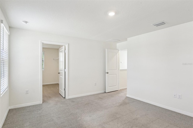 unfurnished room with baseboards, carpet flooring, and visible vents