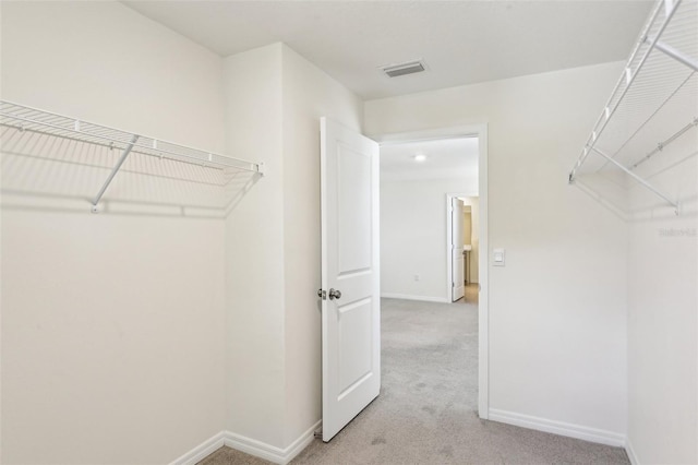 walk in closet with light carpet and visible vents