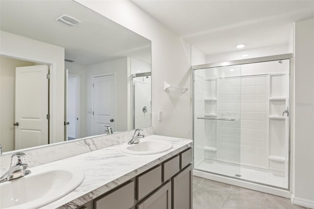 bathroom with tile patterned floors, visible vents, a stall shower, and a sink