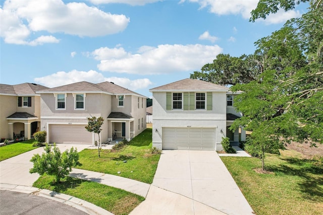view of front of property with concrete driveway, a front yard, stucco siding, and an attached garage