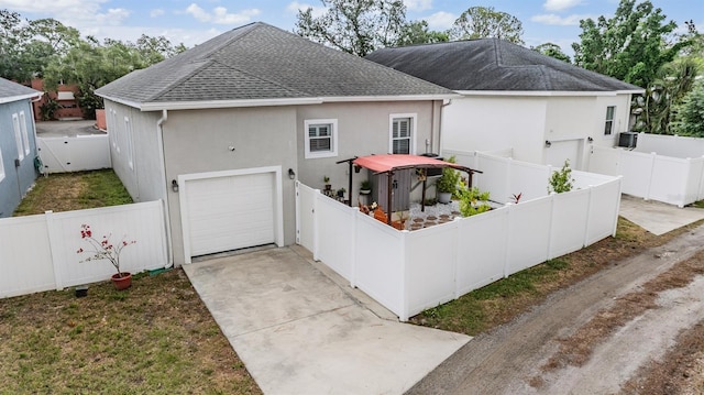 260 SW Lincoln Cir N, Saint Petersburg, FL 33703 - view of front of house featuring a shingled roof, stucco siding, a fenced backyard, and concrete driveway
