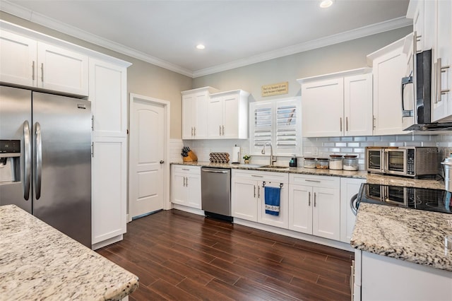 260 SW Lincoln Cir N, Saint Petersburg, FL 33703 - kitchen with appliances with stainless steel finishes, white cabinetry, recessed lighting, a sink, and crown molding