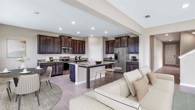 10669 Bridgegate Heights Loop, San Antonio, FL 33576 - kitchen featuring stainless steel appliances, a kitchen breakfast bar, open floor plan, visible vents, and recessed lighting