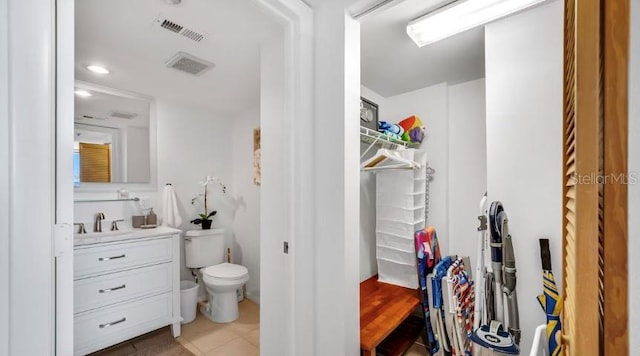 bathroom featuring toilet, tile patterned floors, vanity, and visible vents