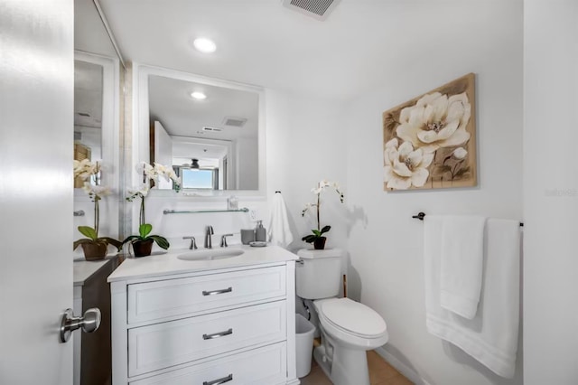 bathroom with vanity, toilet, visible vents, and recessed lighting