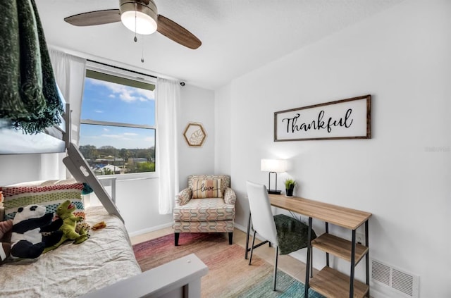 bedroom featuring baseboards, visible vents, a ceiling fan, and wood finished floors