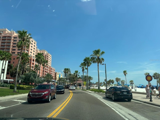 view of road featuring curbs, sidewalks, and street lights