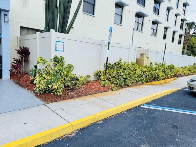 uncovered parking lot featuring fence
