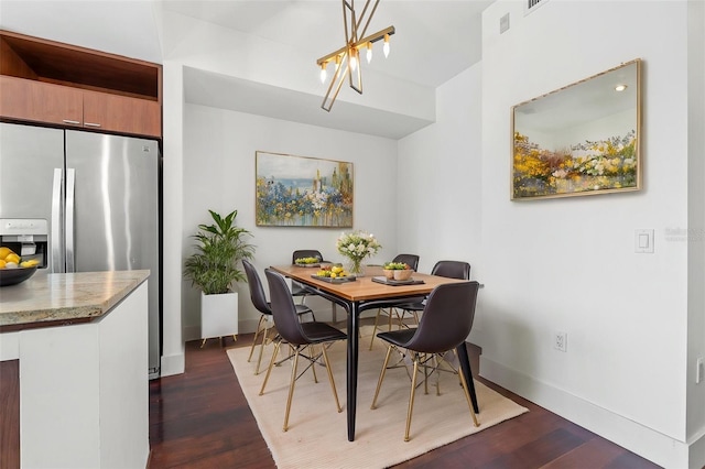 dining room with a chandelier, dark wood-style floors, and baseboards