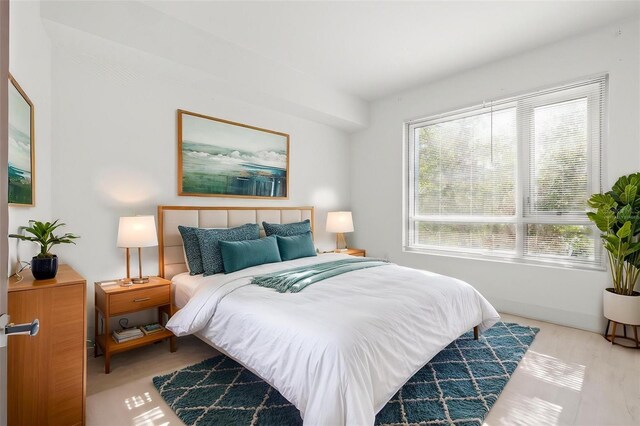 bedroom featuring multiple windows and light wood-style flooring