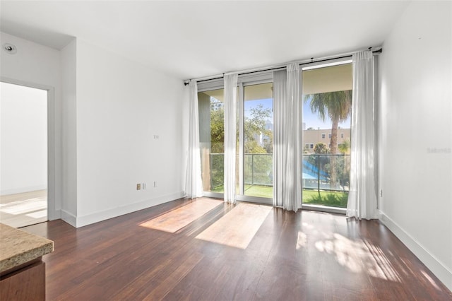 unfurnished room featuring dark wood finished floors and baseboards