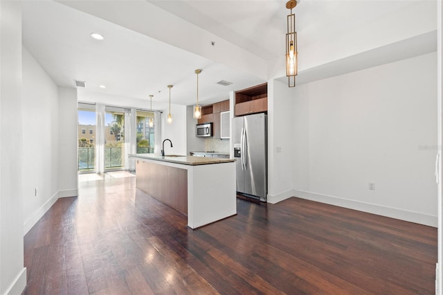 kitchen with appliances with stainless steel finishes, modern cabinets, dark wood-type flooring, baseboards, and a kitchen island with sink