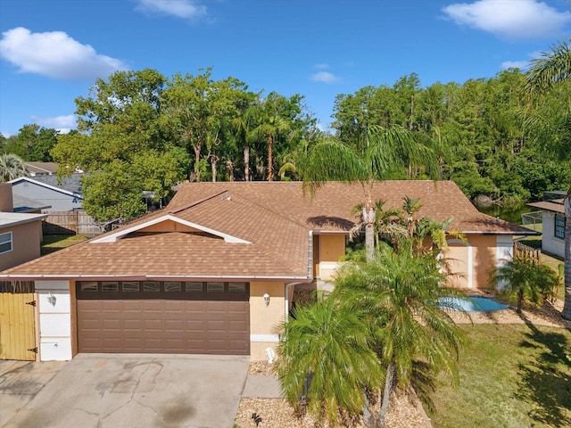view of front of house with driveway, stucco siding, a shingled roof, and an attached garage
