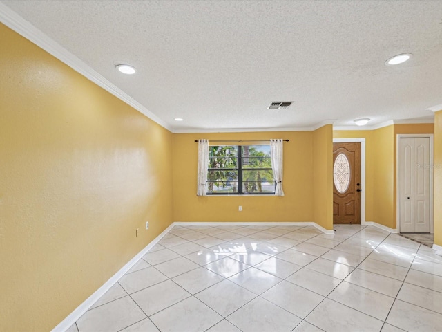 foyer with a textured ceiling, baseboards, and ornamental molding