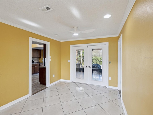 interior space with french doors, a ceiling fan, visible vents, baseboards, and ornamental molding