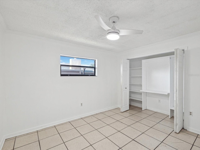 unfurnished bedroom with light tile patterned floors, a closet, a textured ceiling, ceiling fan, and ornamental molding