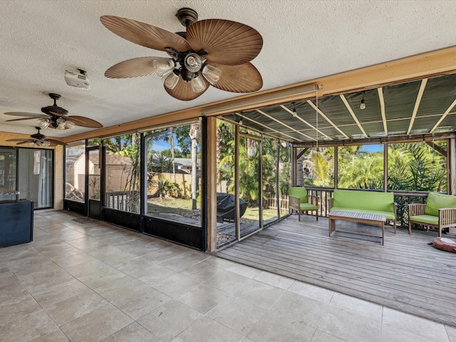 unfurnished sunroom featuring ceiling fan and plenty of natural light