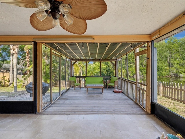 unfurnished sunroom with ceiling fan