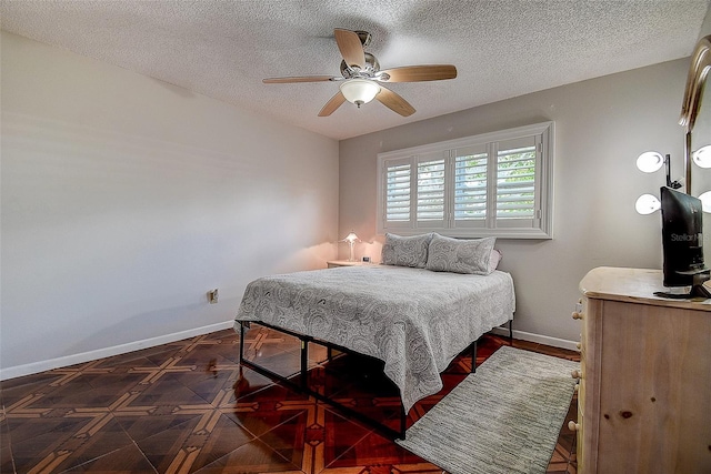bedroom featuring baseboards, a textured ceiling, and a ceiling fan