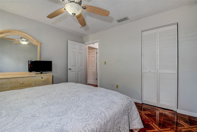 bedroom featuring a textured ceiling, baseboards, a closet, and ceiling fan