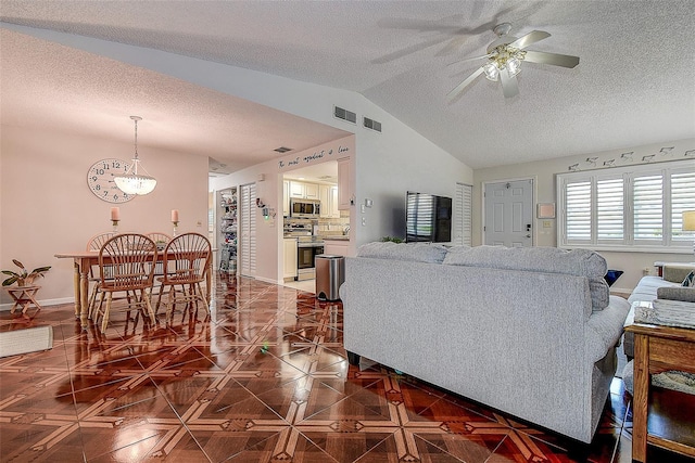 living room with a textured ceiling, ceiling fan, vaulted ceiling, a chandelier, and baseboards